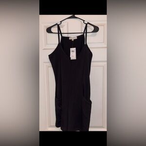 new black spaghetti strap romper w/ front pockets and tags.